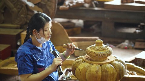 Pattaya , Chonburi / Thailand - 08 26 2020: Female sculptor carving wood in workshop