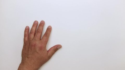 A man's hand rests on the table surface and taps with his fingers. The person waits, then removes it. Isolated video on a white background. Close-up. Warm, soft light. UHD.