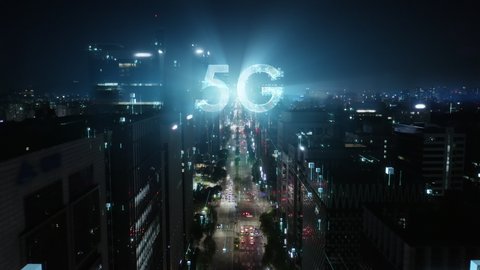 5G technology conсept in the city of the future. Beautiful aerial panorama of modern skyscrapers, streets and traffic all in glittering lights on the night. 