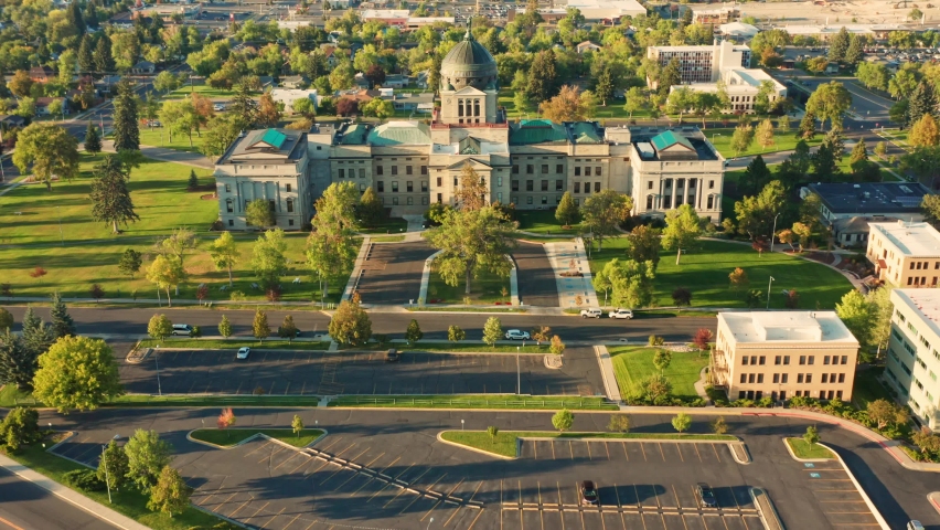 Aerial revealing shot of Helena and Montana State Capitol on a sunny afternoon with hazy sky caused by wildfires. The Montana State Capitol houses the Montana State Legislature.