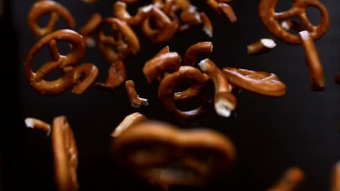 German pretzels on a dark background in super slow motion. Studio macro video