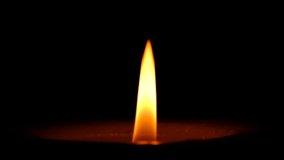 Stearin candle burns on black background high resolution video clip close-up