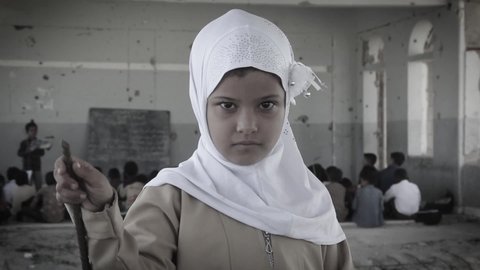 Taiz  Yemen - 07 Oct 2020 : A sad Yemeni child looks at the camera in her school hall, destroyed by the war in the city of Taiz, Yemen