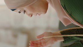 Muslim young woman praying by raising her hand and drawing a rosary.Video for the vertical story.