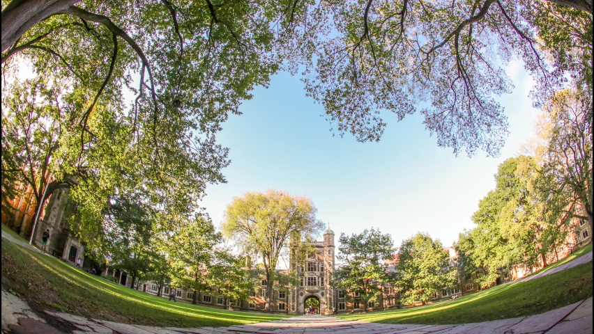 Wide Angle Dolly Time-lapse of University of Michigan Law School on Beautiful Autumn Day - Blue Sky, Sunny Afternoon, Lush, Green Trees and Grass in Foreground, Students Walking Along Cobblestone Path