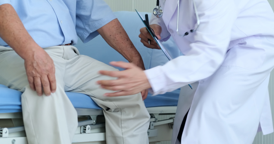 Orthopedist examines the knee of old man patient to gather information for analyze. doctor touch knee of elderly man and talking about knee pain symptom. Royalty-Free Stock Footage #1060749595