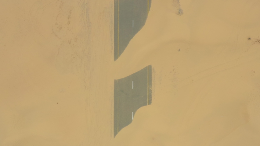 View from above, stunning aerial view of  the Dubai's Half desert road, an abandoned road covered with sand dunes. Dubai, United Arab Emirates Royalty-Free Stock Footage #1060752766