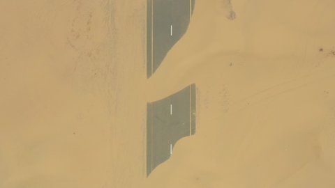 View from above, stunning aerial view of  the Dubai's Half desert road, an abandoned road covered with sand dunes. Dubai, United Arab Emirates