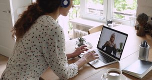 Multiracial businesswomen negotiate using laptop and video call app, screen view where female in hijab talks with colleague, businesspeople work distantly solve issue share thoughts at virtual meeting
