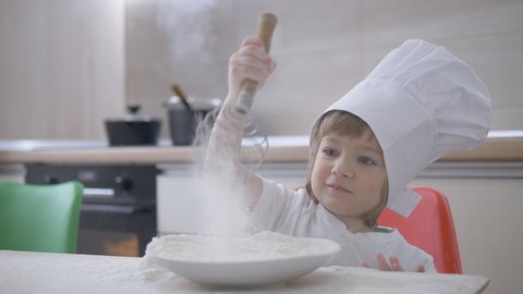 Funny little child whisk in flour, self isolation activity
