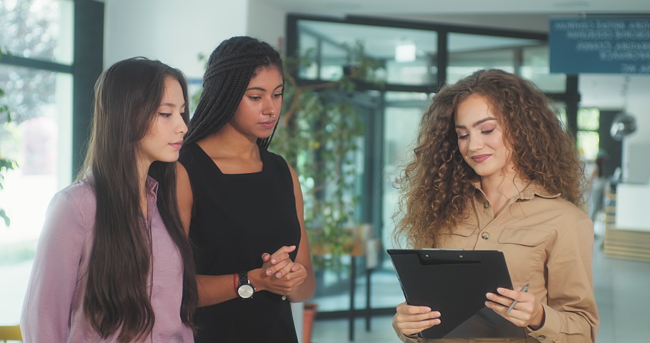 Young business people in discussion, mixed woman race. Creative team meeting in modern work space.  An empowered workplace. 4k slow motion video.
