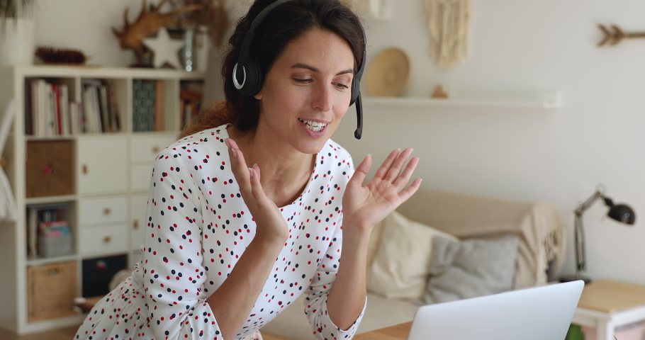 35s female wear headset communicates by conference call speaks look at laptop at home office living room. Videocall event, job interview remotely, distance language class with on-line teacher concept Royalty-Free Stock Footage #1060767085