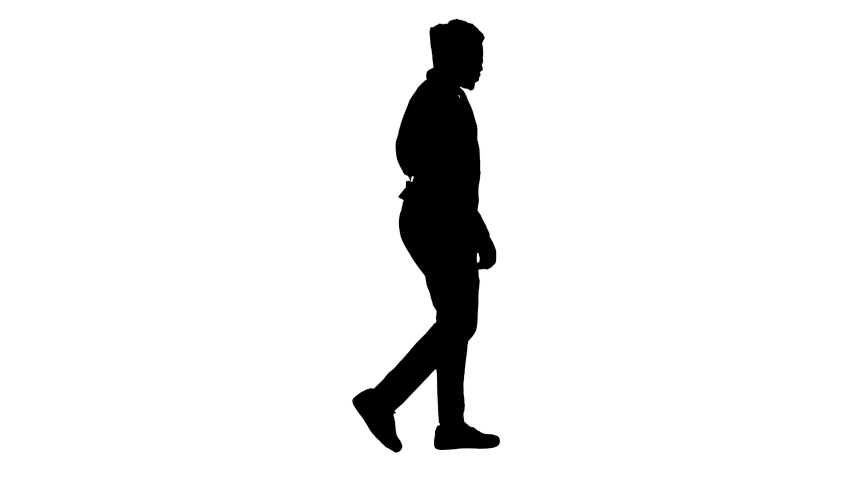 Silhouette Young african american man listening to music in headphones while walking.