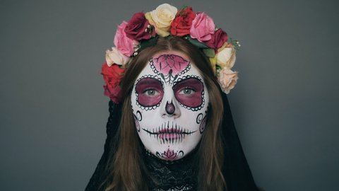 portrait of a woman in the image of death with halloween make-up (Santa Muerte or sugar Mexican skull) close up