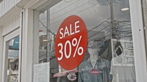 Desa Changgu, Kabupaten Badung, Bali, Indonesia - 7, October 2020: Red round sign hanging on a glass window with the inscription 30% off