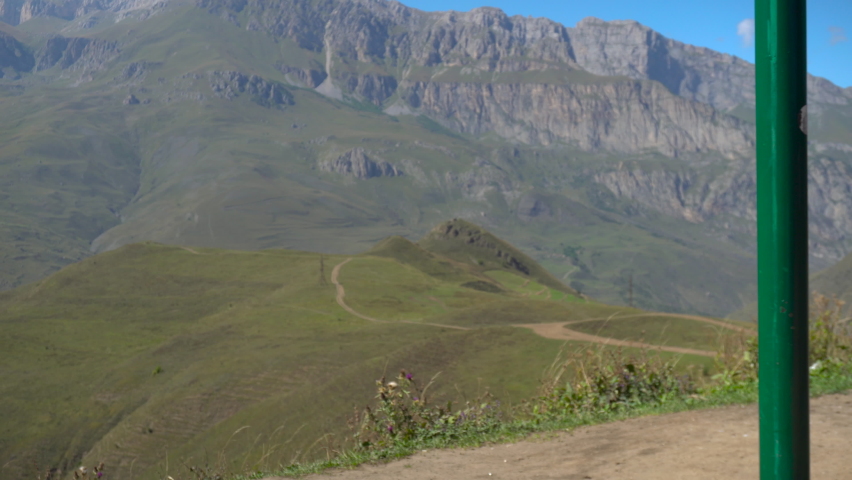 Young woman goes for a drive on a swing against a background of Caucasian mountains.