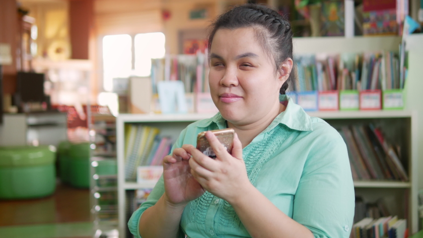 Portrait of Asian young blind person woman enjoy using smart phone with voice accessibility for persons with disabilities in creative workplace. | Shutterstock HD Video #1060776628