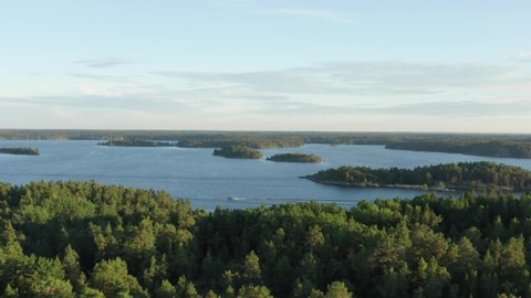 Swedish archipelago in aerial drone shot flying over forest and islands. Swedens most beautiful nature overview shot. Trees and green woods on warm summer evening close to Stockholm city
