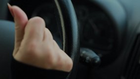 Video, woman hands drive a car, fingers lie on the steering wheel, beautiful fingers with a pink manicure