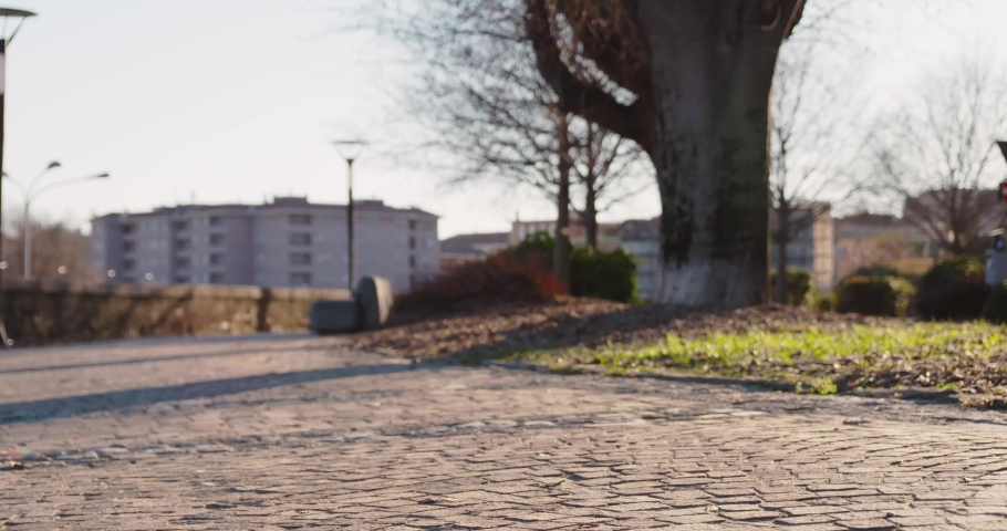 Back view of daughter with her dad riding sideway in autumn park.Modern future transport technology.Active Family.Park sidewalk urban outdoor.Warm sunset cold weather backlight.slow motion 60p video