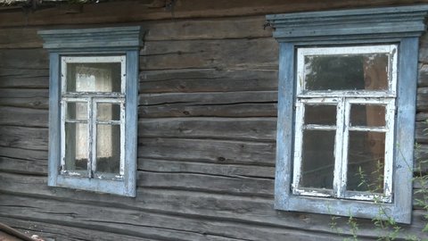 Old wooden house in village. Windows of old, wooden cottage in the countryside.
