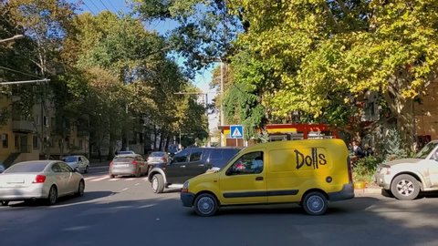 Odessa, Ukraine - 10 14 2020: City traffic through uncontrolled intersection while cars driving and pedestrians walking. Urban transportation time lapse