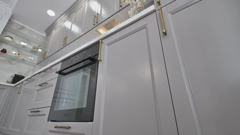 Closeup shot of grey and white contemporary classic kitchen interior with dining table designed in modern style, track camera movement using slider