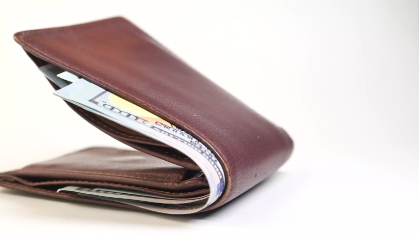 Close up of cash in wallet on table.