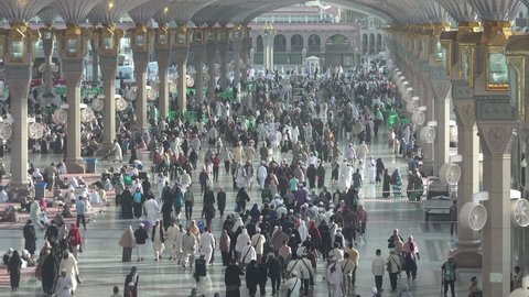 MEDINA, SAUDI ARABIA – DECEMBER 2019: Crowds of Muslim pilgrims from around the world walk through the Prophet's Mosque in Medina, Islamic religion in Saudi Arabia