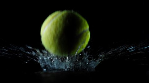 Water splashes from a tennis ball.