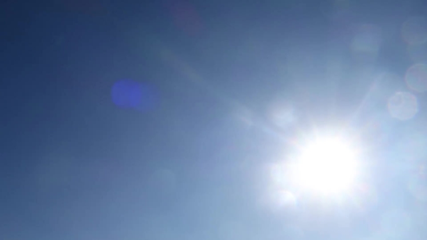 Bright sun light ray with bokeh sunbeam & lens flare shining though white clouds & cumulus cloudscape on sunny clear blue sky background in tropical summer sunlight, Cinemagraphs B-roll TimeLapse Royalty-Free Stock Footage #1060799503