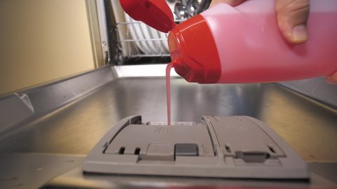 Close up of and pouring detergent cleaning gel into dishwasher