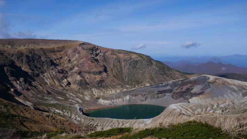 A beautiful giant caldera. Green and blue lake. The movement of clouds. Autumn season. Tourist destinations in Japan. Timelapse