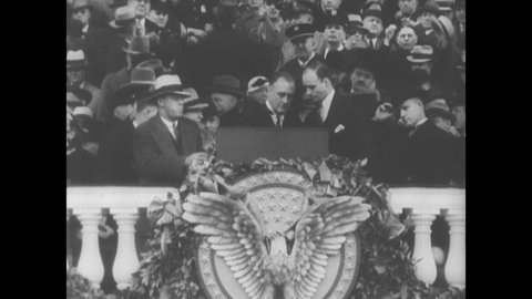 1930s: President Franklin Delano Roosevelt addresses crowds from the steps of the Capitol Building. President Roosevelt shakes hands of men near podium.