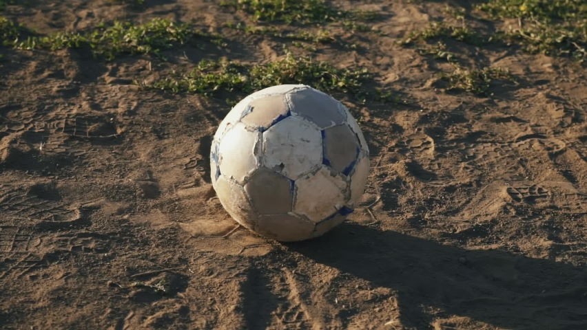 The boy kicks the ball. Football concept. The football player scores the ball into the goal. Street sports in a poor area of a city or village. Training. Childhood memories of a football star. Royalty-Free Stock Footage #1060814428