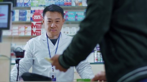 Patient visiting pharmacy store and getting medications for healthcare. Close-up of customer paying contactless payment on NFC technology. Buying medicine. Drugstore.