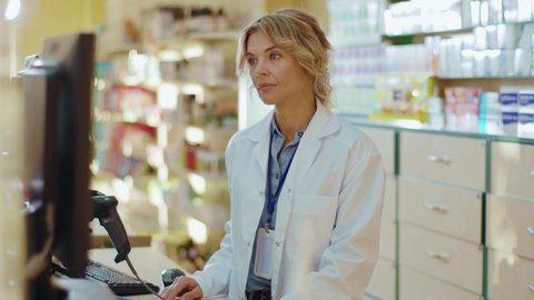 At sunlight woman pharmacist serving a customer in a drugstore. Conversation pharmaceutical client. Seller commercial health care buyer uniform. Slow motion