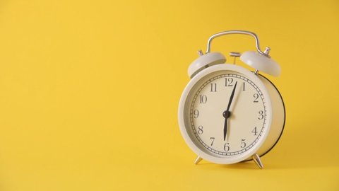 Alarm clock and falling dollars on yellow background. Time money concept
