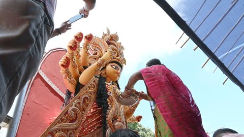 Howrah, West Bengal, India- 8th October 2019 : Vijayadashami, married Bengali Hindu woman applying sindur, vermilion, on the forehead of Goddess Durga and offering sweets . Durga puja festival ritual.