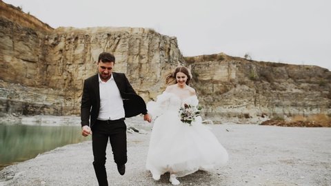 Wedding love story of an elegant couple on the coast of an abandoned canyon with turquoise water