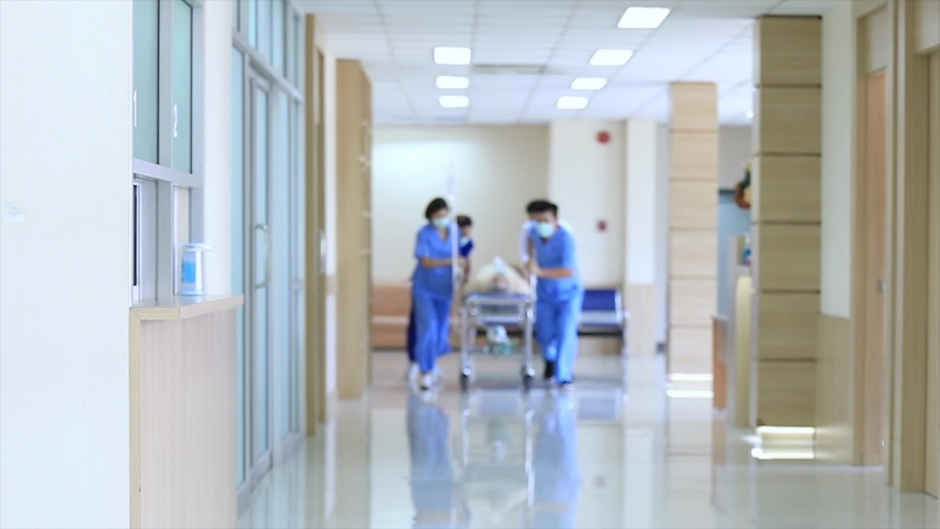 Group of Asian doctors and nurses team wearing face mask, push emergency stretcher, transport senior patient Through Hospital Corridors. Medical rescue team in a Hurry Move Patient operation concept. Royalty-Free Stock Footage #1060828894