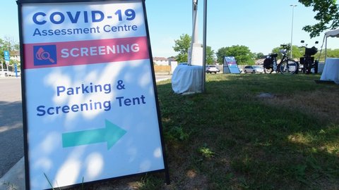 Covid-19 Assessment Centre Screening Parking and Screening Tent sign near hospital in the city. Coronavirus test for workers due pandemic. The fight with virus and second wave control.