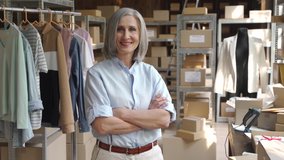 Confident happy mature older 60s woman retail seller, entrepreneur, clothing store small business owner, supervisor looking at camera standing arms crossed in delivery shipping warehouse, portrait. - Powered by Shutterstock - Get 15% off with code: PIKWIZARD15