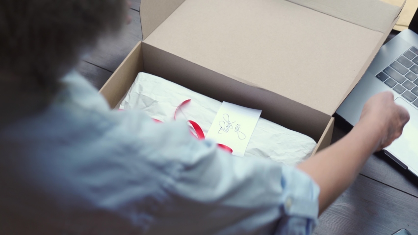 Close up over shoulder view of old female online store small business owner worker packing package post shipping ecommerce retail order in box preparing delivery parcel on table. Dropshipping service. Royalty-Free Stock Footage #1060830655