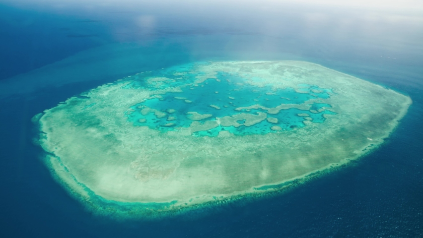 Aerial view of Queensland Coral Reef Island from a flying airplane. Slow motion