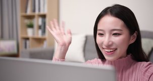 close up of asian young woman has video chat by laptop computer with friend happily in the living room at home