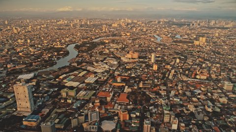 Metropolis cityscape at river banks aerial. Downtown area with cottages, skyscrapers, buildings. Urban Philippines city scape with streets and roads. Cinematic Manila town drone shot