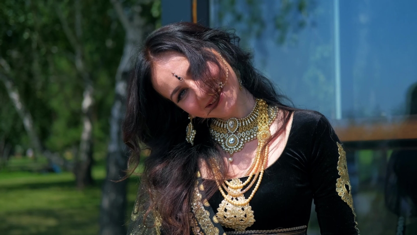 Female model in asian ethnic indian costume with  jewellery and traditional makeup. Woman dancing belly dance in oriental dress. Bollywood style