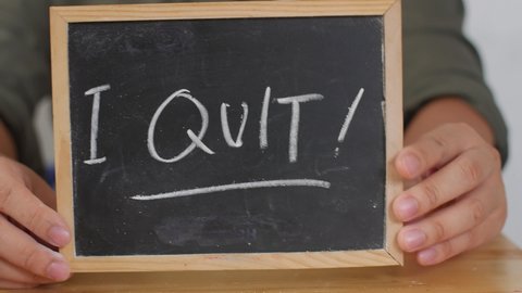 I Quit. Male writing on chalkboard. Quitting job concept