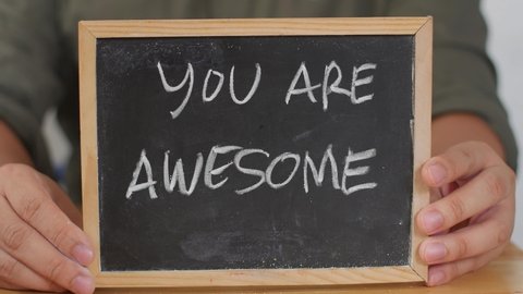 You are awesome. Male writing on chalkboard. motivational inspirational quote text concept